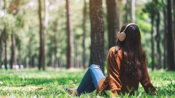 Woman relaxing in forest with headphones on