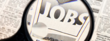 Magnifying glass over the jobs sections of a newspaper