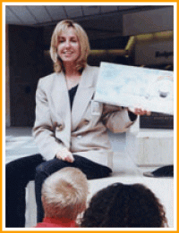 Woman reading to children while showing them the pictures in the book